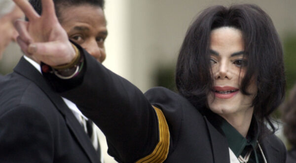 FILE - In this March 2, 2005, file photo, pop icon Michael Jackson waves to his supporters as he arrives for his child molestation trial at the Santa Barbara County Superior Court in Santa Maria, Calif. A new documentary on HBO, "Leaving Neverland," is about the abuse allegations of two men, Wade Robson and James Safechuck, who had previously denied Jackson molested them and supported him to authorities and in Robson's case, very publicly. (AP Photo/Michael A. Mariant, File)