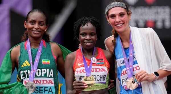 Gold medalist Kenya's Peres Jepchirchir, center, poses with silver medalist Ethiopia's Tigst Assefa and bronze medalist Uruguay's Julia Paternainafter finishing the women's marathon at the World Athletics Championships in Tokyo, Sunday, Sept. 14, 2025. (AP Photo/Matthias Schrader) Japan Athletics Worlds