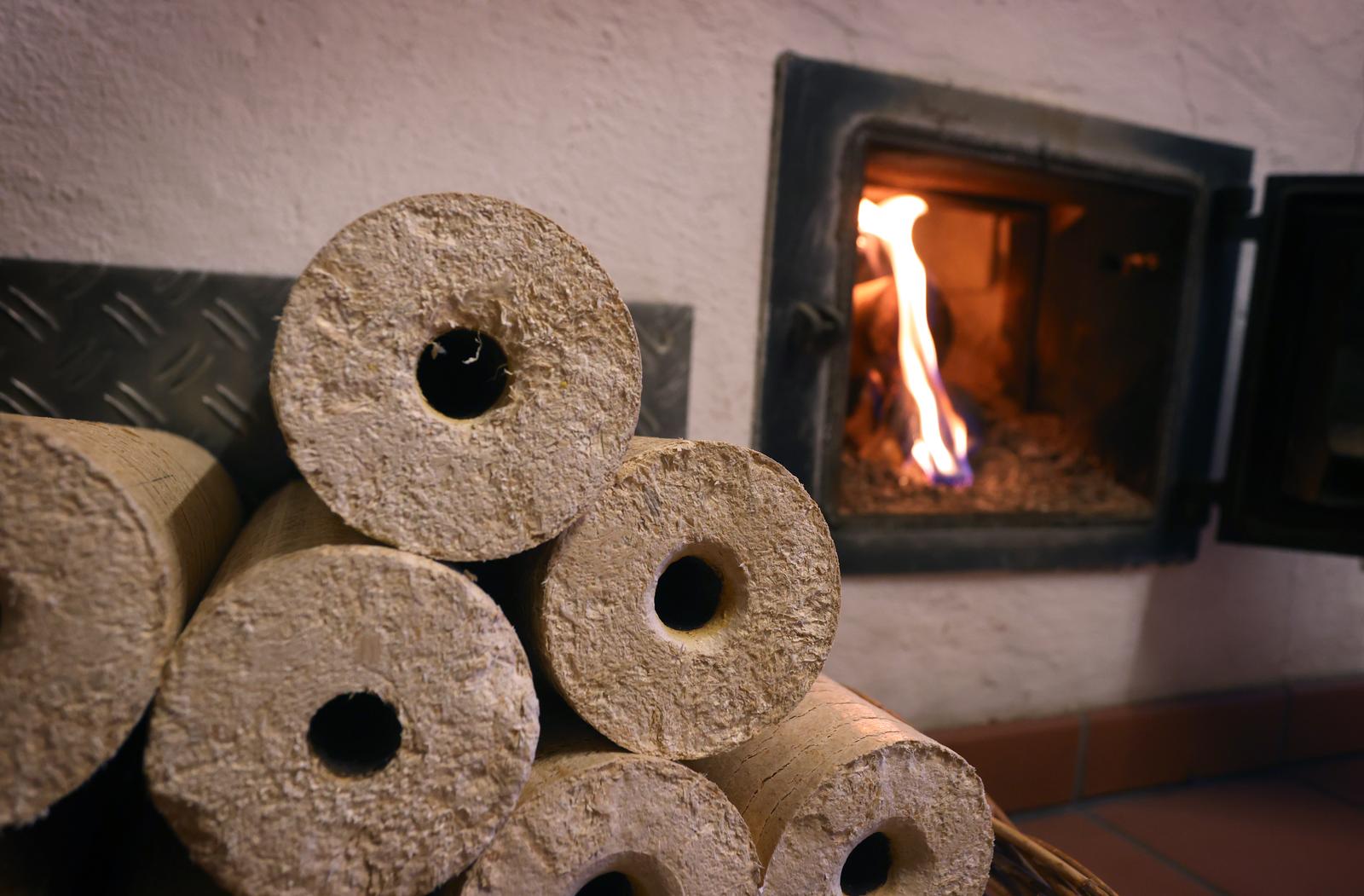 PRODUCTION - 08 November 2021, Bavaria, Kaufbeuren: A wood stove is heated from the hallway with wood briquettes. Photo: Karl-Josef Hildenbrand/dpa Photo: Karl-Josef Hildenbrand/DPA