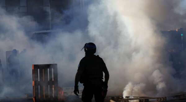 epa12366434 A Police officer walks as protesters burn wooden pallets while blocking streets during a call for action by 'Bloquons tout' (Block everything) collective in Montpellier, France, 10 September 2025. In a protest against the outgoing government's austerity budget, an online collective called 'Bloquons Tout' has called for everyone to block the entire country on 10 September with symbolic actions.  EPA/GUILLAUME HORCAJUELO