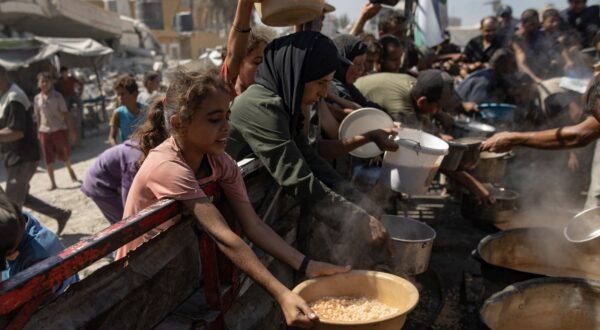 epa12370814 Palestinians, including children, hold pots as they queue to receive food from a kitchen that provides free food for displaced people in Gaza City, northern Gaza Strip, 12 September 2025. According to the UN, around 90 percent of the population, or 1.9 million people, in Gaza have been displaced since the start of the conflict.  EPA/HAITHAM IMAD