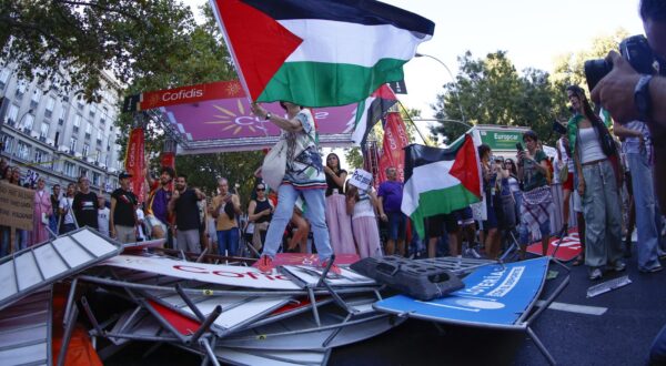 epa12376924 Demonstrators, some holding Palestinian flags, disrupt the cyclists' route on Paseo del Prado during the 21st and last stage of La Vuelta a Espana cycling race, a 103.6 km race between Alalpardo and Madrid, in Madrid, Spain, 14 September 2025.  EPA/Rodrigo Jimenez
