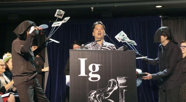 Tomoki Kojima (C), a researcher at the National Agriculture and Food Research Organization, wearing a zebra-patterned shirt, explains his team's findings at an Ig Nobel prize ceremony at Boston University in Boston on Sept. 18, 2025. The team won the Ig Nobel prize in biology for their experiment showing that painting zebra-like stripes on cattle significantly reduces the number of biting flies landing on them. (Kyodo) ==Kyodo  Photo via Newscom