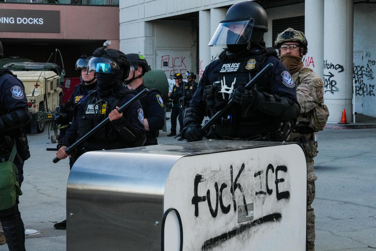 EDITOR'S NOTE : Image depicts profanity Heavily armed federal agents, including members of U.S. Customs and Border Protection and Homeland Security, stand guard near a block marked with black spray-painted graffiti reading fuck ICE during an anti-ICE demonstration. Demonstrators staged a protest as part of a citywide action against U.S. Immigration and Customs Enforcement (ICE), where protesters called for the end of deportations, the shutdown of detention centers, and protection for migrant communities across the United States. (Photo by Alvaro Diaz / SOPA Images/Sipa USA) Photo: SOPA Images/SIPA USA