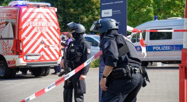 05 September 2025, North Rhine-Westphalia, Essen: Police officers stand at a barrier with flutter tape at a vocational college in Essen. A teacher at the vocational college was attacked and injured by a perpetrator with a knife. According to security sources, the perpetrator was a pupil at the school. He fled the scene. Photo: Henning Kaiser/dpa Photo: Henning Kaiser/DPA