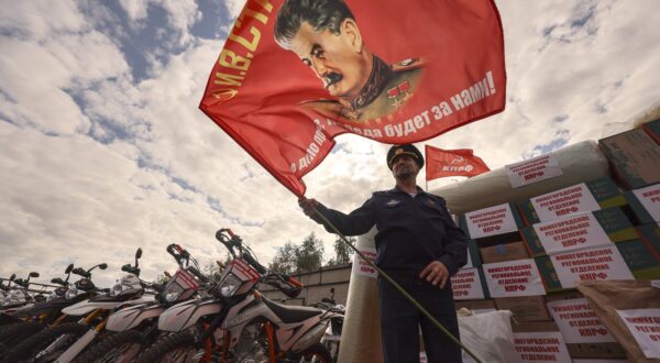 epa12361943 A Russian serviceman holds a red flag with a portrait of Soviet leader Josef Stalin during the send-off of the 143rd humanitarian convoy organized by the Russian Communist Party for the Russian army and residents of the Kursk, Donetsk and Luhansk regions, at the Lenin State Farm outside Moscow, Russia, 08 September 2025. The convoy is dedicated to the 80th anniversary of the Red Armys victory over Japan and the end of World War II in 1945. It contains food, medicine, drones and hundreds of motocross motorcycles, which are used by the military on the front line for assault operations.  EPA/SERGEI ILNITSKY
