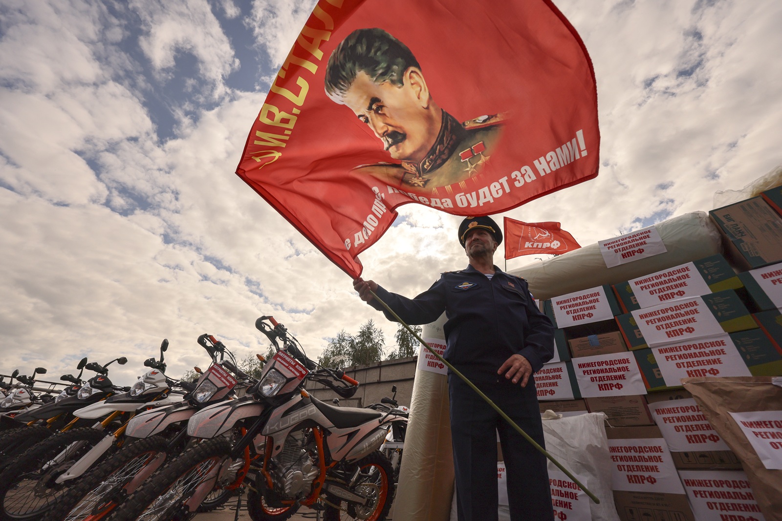 epa12361943 A Russian serviceman holds a red flag with a portrait of Soviet leader Josef Stalin during the send-off of the 143rd humanitarian convoy organized by the Russian Communist Party for the Russian army and residents of the Kursk, Donetsk and Luhansk regions, at the Lenin State Farm outside Moscow, Russia, 08 September 2025. The convoy is dedicated to the 80th anniversary of the Red Armys victory over Japan and the end of World War II in 1945. It contains food, medicine, drones and hundreds of motocross motorcycles, which are used by the military on the front line for assault operations.  EPA/SERGEI ILNITSKY
