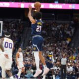 Denver Nuggets guard Jamal Murray, center, shoots a 3-point basket as Phoenix Suns forward Royce O'Neale, left, and guard Grayson Allen, right, look on as time runs out in the first quarter of an NBA basketball game Saturday, Oct. 25, 2025, in Denver. (AP Photo/David Zalubowski) Suns Nuggets Basketball
