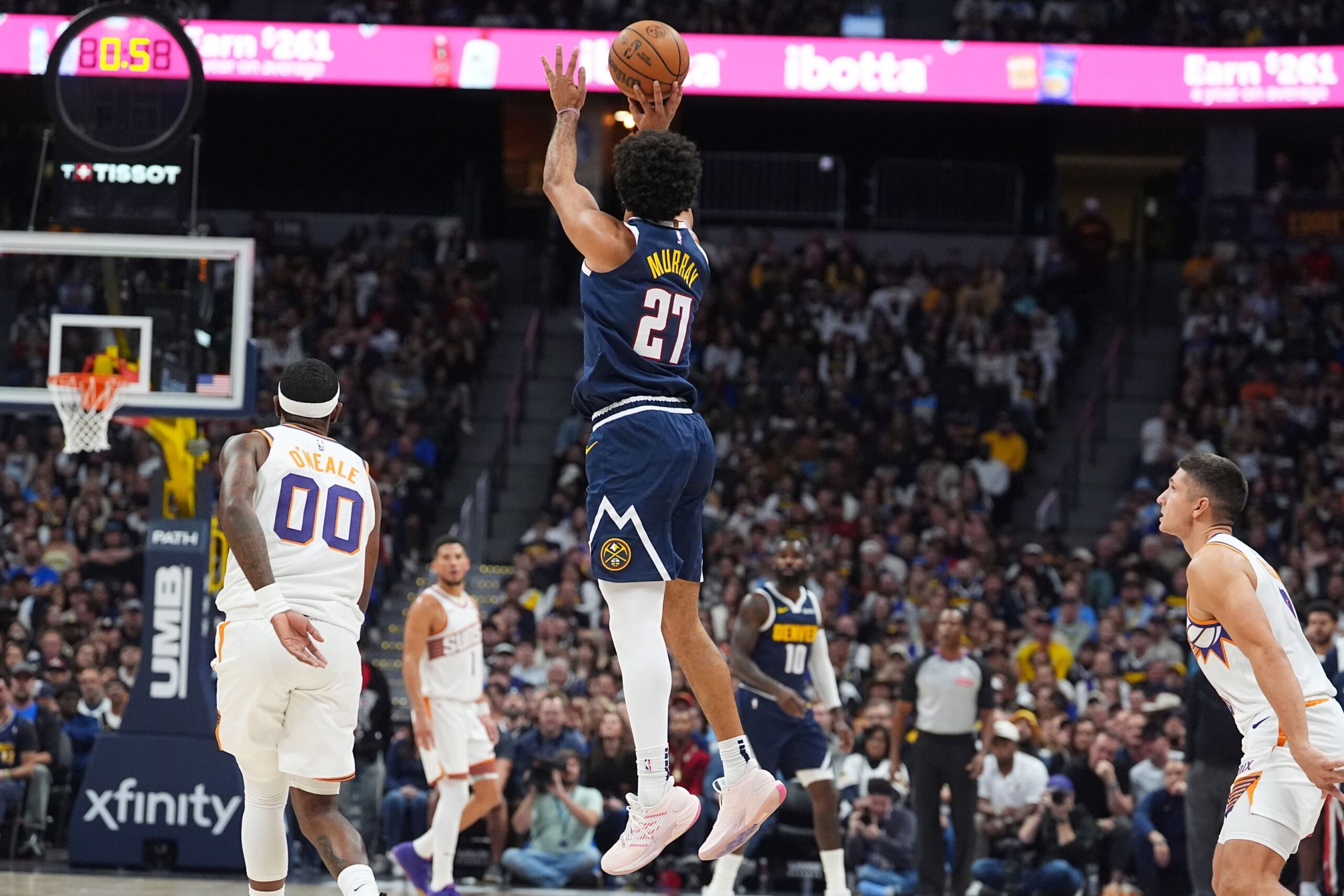 Denver Nuggets guard Jamal Murray, center, shoots a 3-point basket as Phoenix Suns forward Royce O'Neale, left, and guard Grayson Allen, right, look on as time runs out in the first quarter of an NBA basketball game Saturday, Oct. 25, 2025, in Denver. (AP Photo/David Zalubowski) Suns Nuggets Basketball