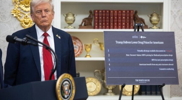 epa12417475 US President Donald Trump stands near a sign on lowering drug prices for Americans as he announces a drug-pricing deal with Pfizer in the Oval Office at the White House in Washington, DC, USA, 30 September 2025.  EPA/FRANCIS CHUNG / POOL