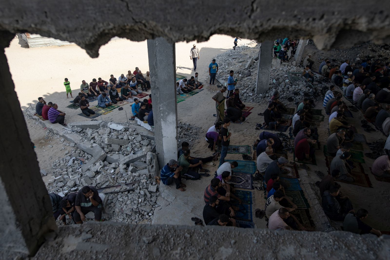 epa12459859 Internally displaced Palestinians perform the first Friday prayers after the Israel-Hamas ceasefire amid the ruins of the destroyed Al-Albani Mosque in the Khan Yunis camp, southern Gaza Strip, 17 October 2025. The ceasefire is part of the first phase of a Gaza peace plan that includes a halt in fighting, the release of hostages and prisoners, and the delivery of humanitarian aid.  EPA/HAITHAM IMAD