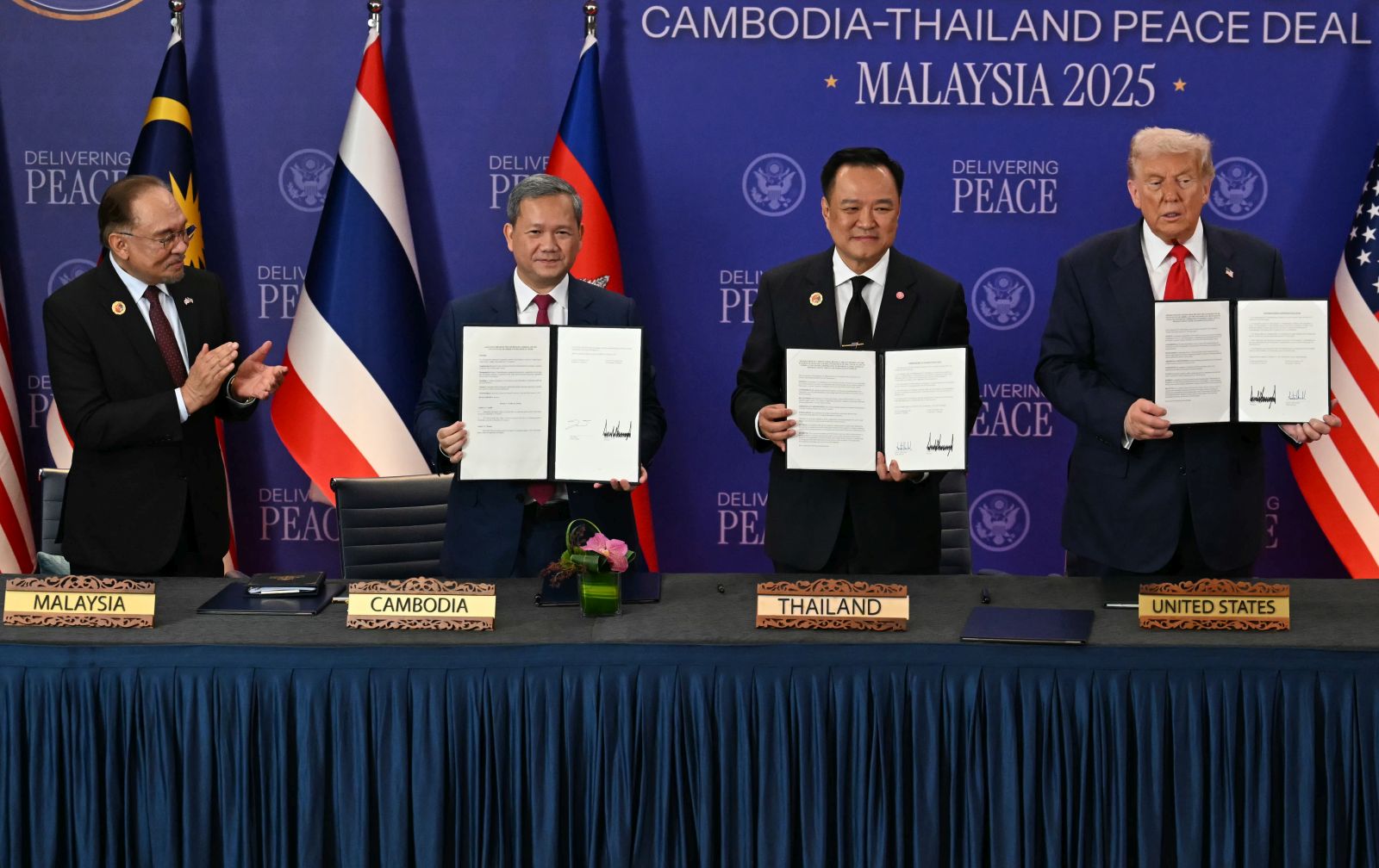 epa12483094 (L-R) Malaysia's Prime Minister Anwar Ibrahim applauds as Cambodia's Prime Minister Hun Manet, Thailand's Prime Minister Anutin Charnvirakul and US President Donald Trump hold up documents during the ceremonial signing of a ceasefire agreement between Thailand and Cambodia on the sidelines of the 47th Association of Southeast Asian Nations (ASEAN) Summit in Kuala Lumpur, Malaysia, 26 October 2025.  EPA/MOHD RASFAN / POOL