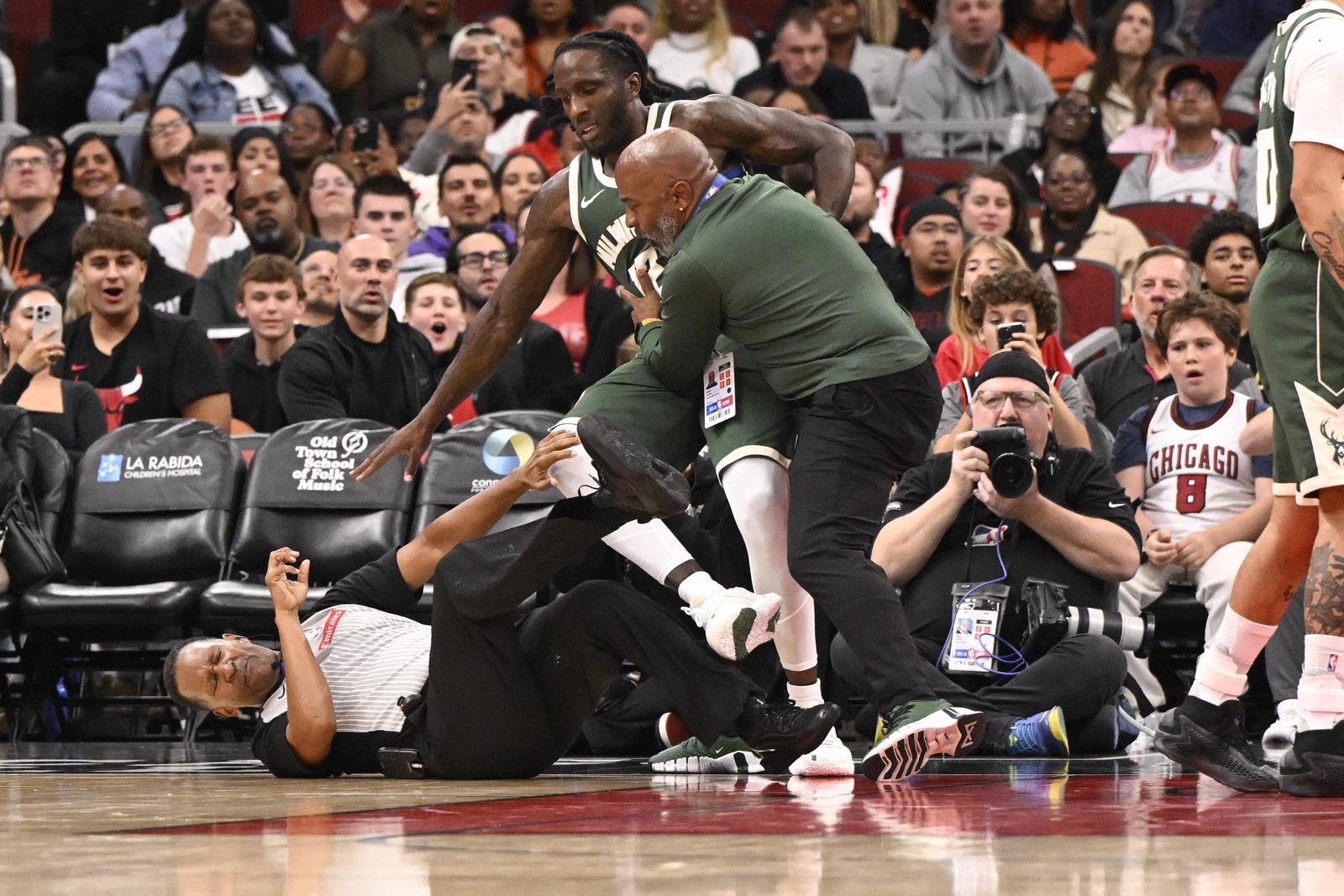Oct 12, 2025; Chicago, Illinois, USA;  Official James Capers gets knocked down during a fight between Milwaukee Bucks forward Taurean Prince (12), left, and Chicago Bulls forward Dalen Terry (7), right, during the second half at the United Center. Mandatory Credit: Matt Marton-Imagn Images/Sipa USA Photo: Imagn Images/SIPA USA