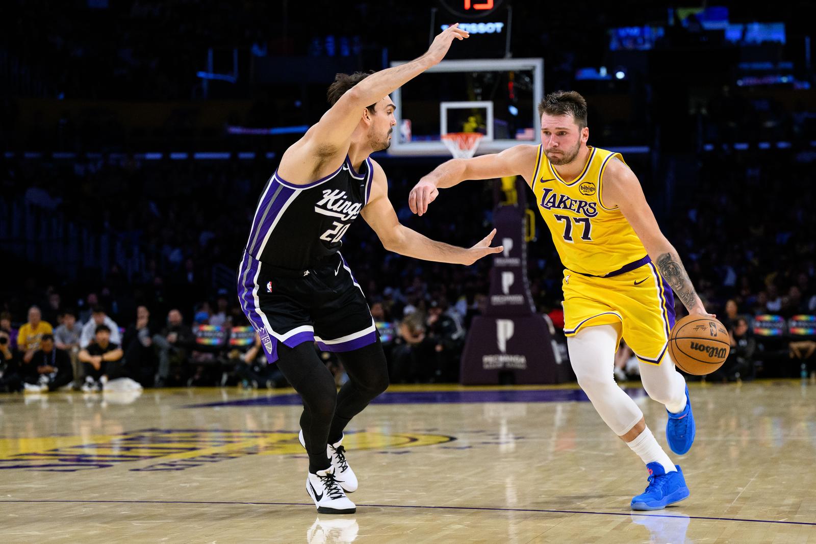 Oct 17, 2025; Los Angeles, California, USA; Los Angeles Lakers forward/guard Luka Doncic (77) drives the ball against Sacramento Kings forward/center Dario Saric (20) during the second half at Crypto.com Arena. Mandatory Credit: William Liang-Imagn Images/Sipa USA Photo: Imagn Images/SIPA USA