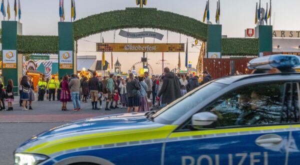 01 October 2025, Bavaria, Munich: A police car drives past the entrance to the Oktoberfest grounds after admission. After being closed due to a bomb threat, the Munich Oktoberfest has reopened. Photo: Armin Weigel/dpa Photo: Armin Weigel/DPA