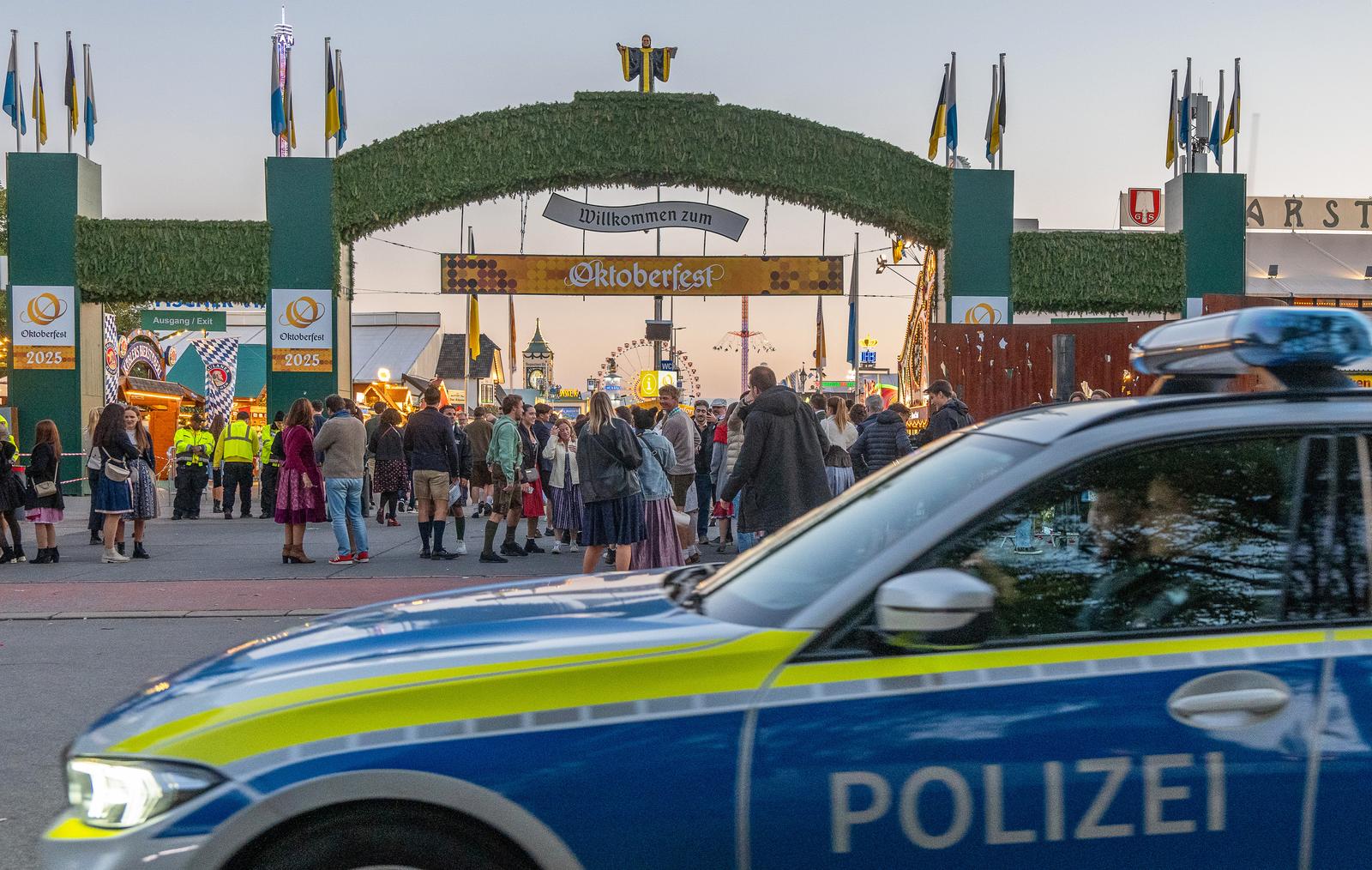 01 October 2025, Bavaria, Munich: A police car drives past the entrance to the Oktoberfest grounds after admission. After being closed due to a bomb threat, the Munich Oktoberfest has reopened. Photo: Armin Weigel/dpa Photo: Armin Weigel/DPA